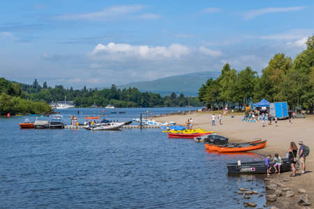 Loch Lomond, Scotland - July 25th 2021: Water sports, boats and kayaks on the shore of Loch Lomond at Balloch in summer, Scotlandのeditorial素材
