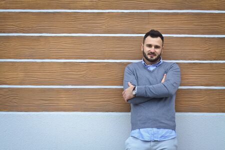 Portrait of a handsome man in a shirt on a wooden wall background. Businessman, boss in stylish clothes. Stock Photo for designの写真素材