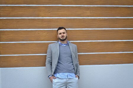 Portrait of a handsome man in a shirt on a wooden wall background. Businessman, boss in stylish clothes. Stock Photo for designの写真素材