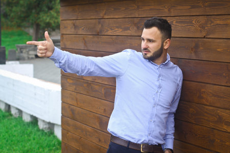 Portrait of a handsome man in a shirt on a wooden wall background. Businessman, boss in stylish clothes. Stock Photo for designの写真素材
