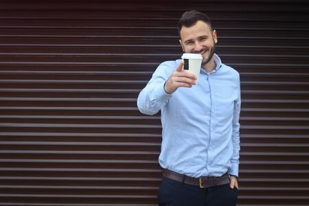 Portrait of a businessman, manager on a striped wall background. Bearded sexy man singing coffee, tea. Stock photosの写真素材