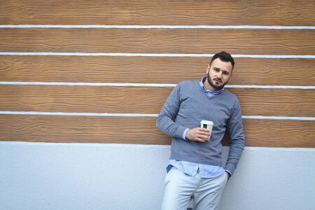 Portrait of a handsome man in a shirt on a wooden wall background. Businessman, boss in stylish clothes. Stock Photo for designの写真素材