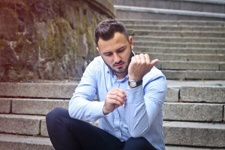 Portrait of a bearded man near the big steps of an old European castle. Businessman thinking over a future project. Fashionable guy with stylish clothes.の写真素材