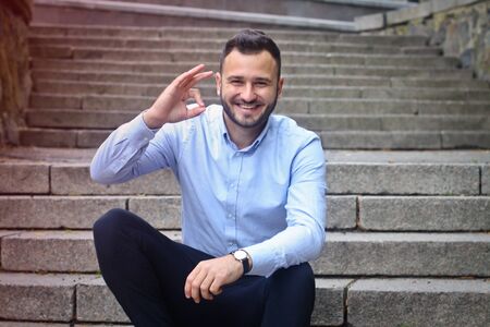 Portrait of a bearded man near the big steps of an old European castle. Businessman thinking over a future project. Fashionable guy with stylish clothes.の写真素材