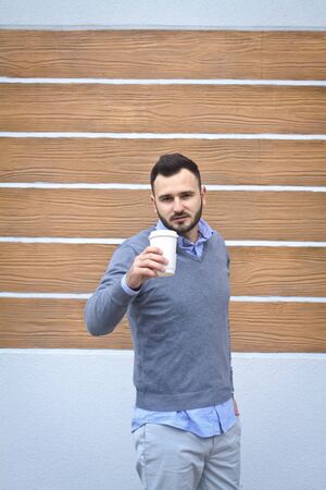 Portrait of a handsome man in a shirt on a wooden wall background. Businessman, boss in stylish clothes. Stock Photo for designの写真素材