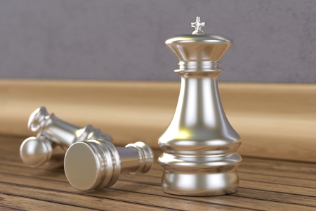 Silver chess pieces on wooden floorの写真素材