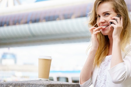 Young cheerful woman talking on her cell phoneの写真素材