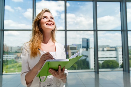 Young beautiful woman holding green notebook.の写真素材