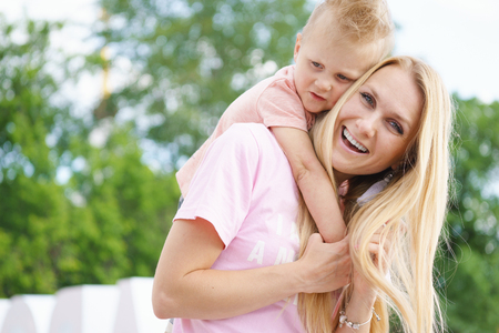 Young son hugs mom at outdoorの写真素材