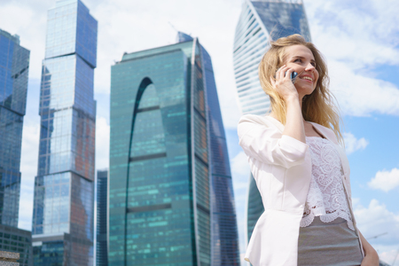 Smiling young business woman having pleasant conversation on mobile phoneの写真素材