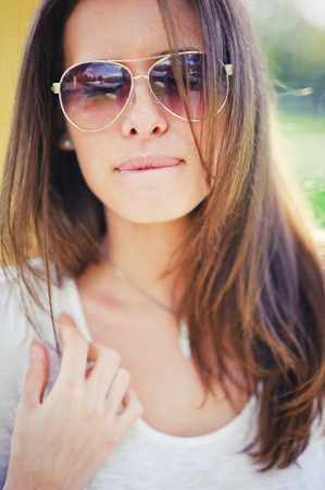 Outdoor portrait of beautiful girl with sunglassesの写真素材