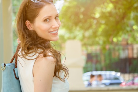 Closeup portrait of smiling beautiful brunette woman looks back.の写真素材