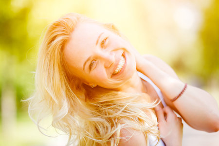 Blonde woman threw back her head. Image with lens flare effectの写真素材