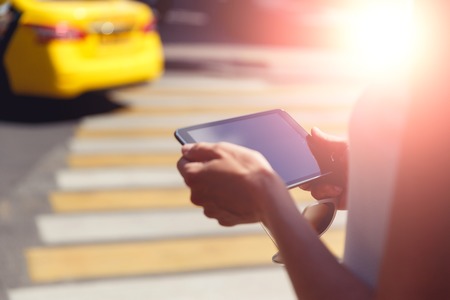 Female hands closeup holding sunglasses and modern tablet. Image with lens flare effectの写真素材