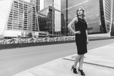 Black and white portrait of business woman in full growth on the urban landscape