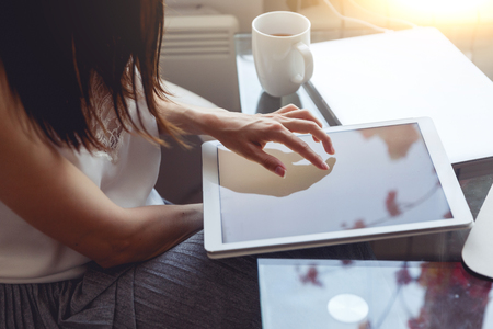 Closeup of brunette woman using tablet in cafe. Image with lens flare effect and split tonedの写真素材