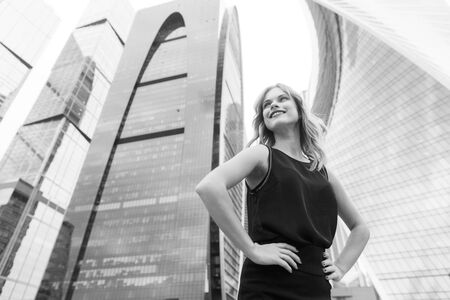 Black and white portrait of young business lady against of modern buildings backgroundの写真素材