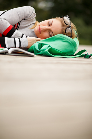 sleeping blonde on backpack outdoors. blank spaceの写真素材