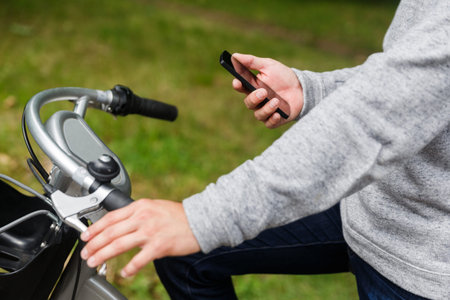 Male figure on the bike with smartphone, portrait on summer day