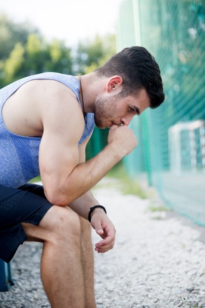 Sports man sitting and relaxing after workout on natureの写真素材