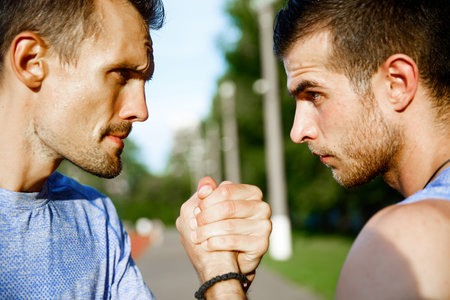 Portrait on nature of two emotional men handshake on hot summer dayの写真素材