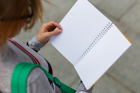 Girl spectacled holds open notebook, top viewの写真素材