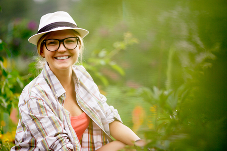 Portrait of female gardener among the plants in summer seasonの写真素材
