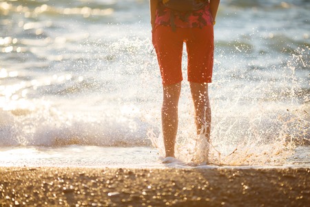 Girl in shorts jumped into water at seasideの写真素材