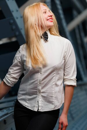 Smiling ginger girl in white shirt standing indoorsの写真素材
