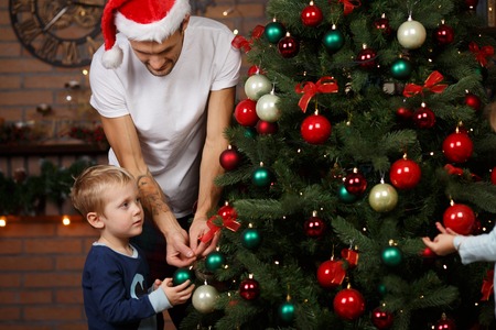 Dad with little son adorn Christmas treeの写真素材