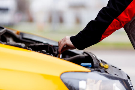 Driver opened hood of yellow taxi in afternoon