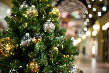 Festive fir with gold ornaments on ablurred background shopping centerの写真素材