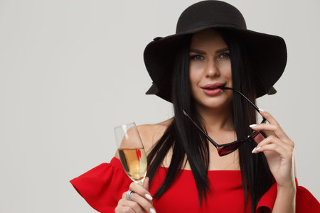 Festive girl with sunglasses in red dress isolated on gray background