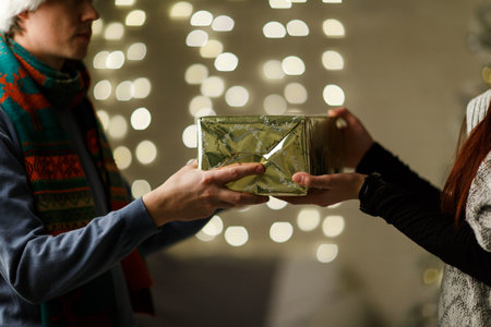Giftbox in hands of girl and guy in Christmas