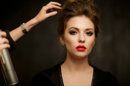 Stylist corrects hair of womanの写真素材