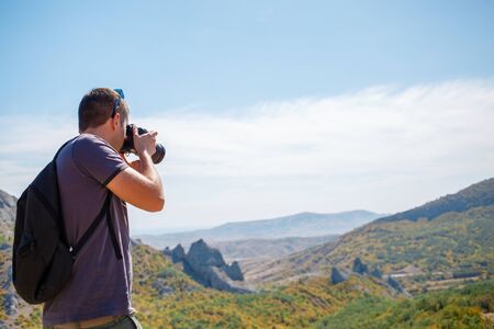 Man photographing mountain in summerの写真素材