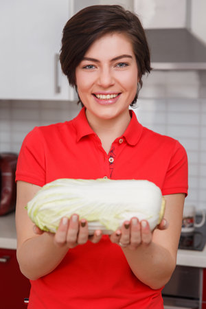 Smiling woman holding Chinese cabbageの写真素材