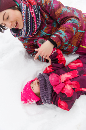 Woman,daughter on snowy roadの写真素材