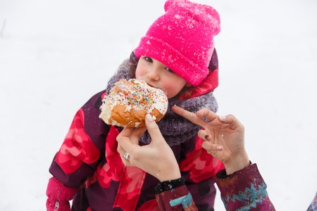 Girl eats bun for walkの写真素材