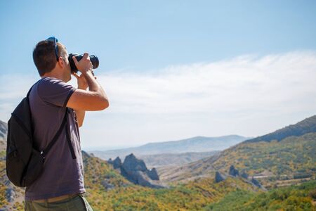 Guy photographing mountain in summerの写真素材