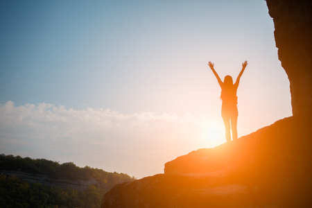 Woman on mountain against sunの写真素材