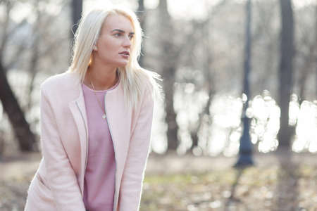 Blonde in coat in woodsの写真素材