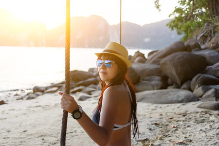 Woman in hat on swingの写真素材