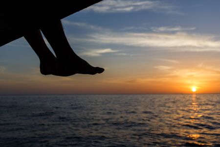 Scarlet sunset with seated manの写真素材