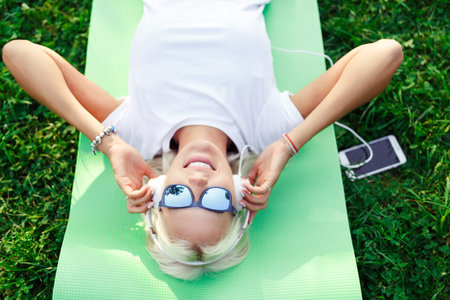 Picture of girl in headphones at lawnの写真素材