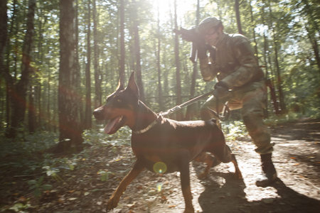 Image of soldier in helmet and with submachine gun and dog