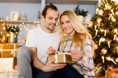 Sweet couple opening Christmas giftsの写真素材