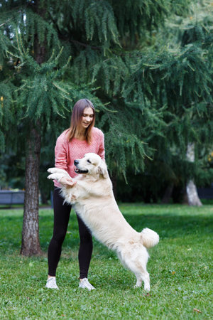 Image of woman holding dog by front paws