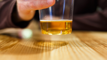 Image of man with glass of beer on tableの写真素材