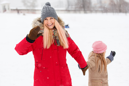 Photo of happy mother and daughter on walk in winter parkの写真素材